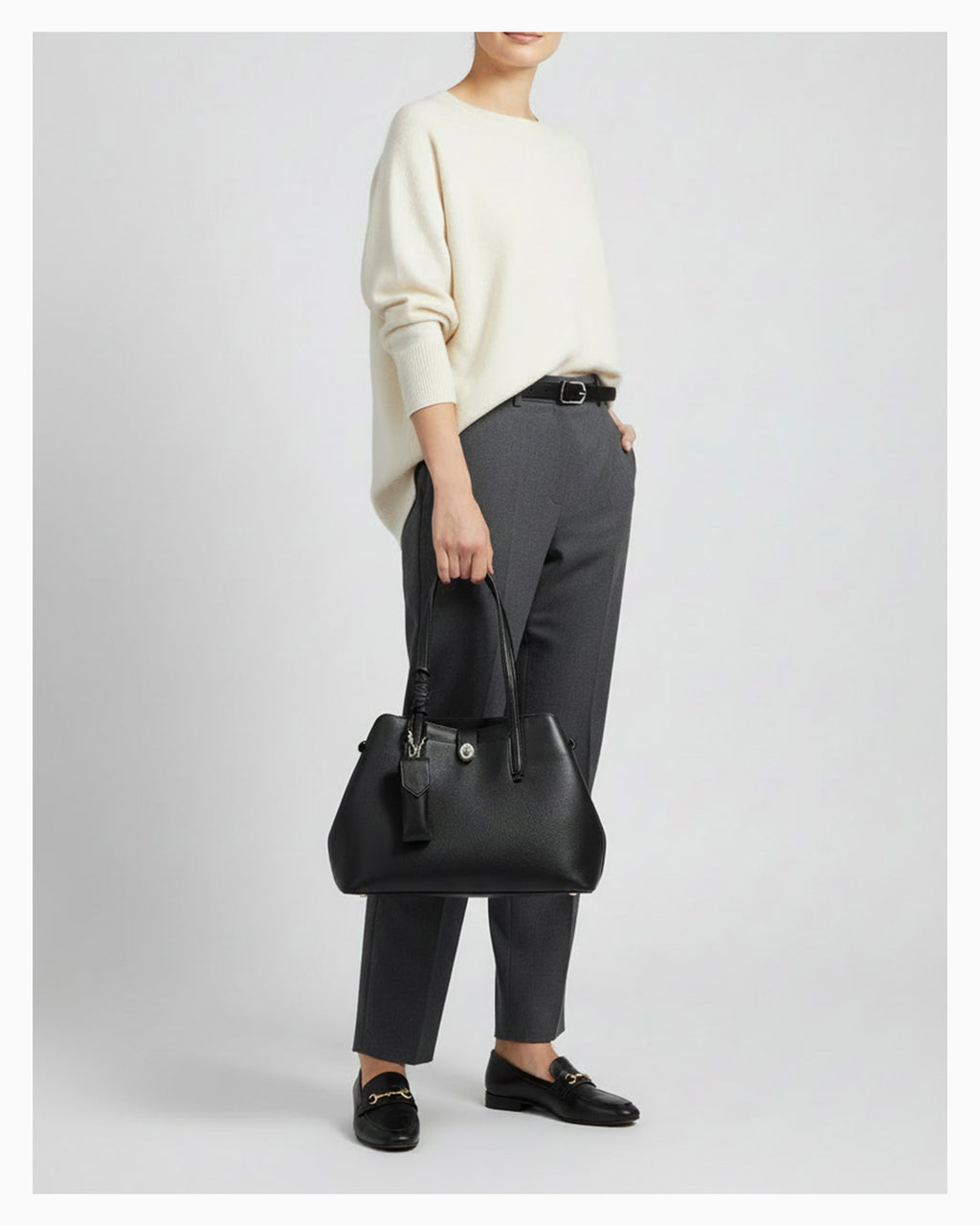 A woman in an elegant smart-casual outfit with a Genuine Leather Black Tote Bag with Spacious Interior and Detachable Leather Lipstick Pouch