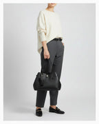 A woman in an elegant smart-casual outfit with a Genuine Leather Black Tote Bag with Spacious Interior and Detachable Leather Lipstick Pouch
