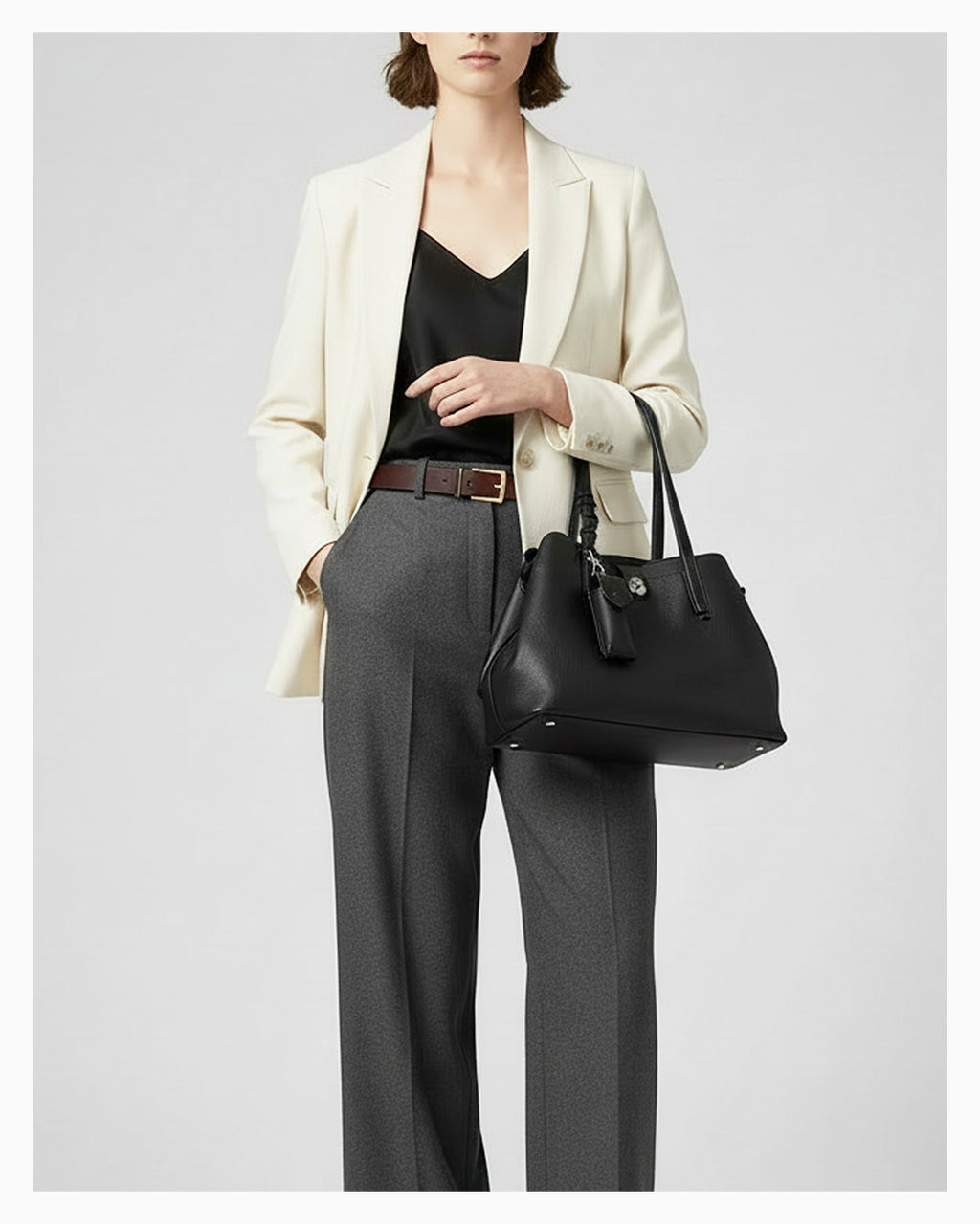 Woman in a smart-casual outfit with an Elegant Genuine Leather Black Tote Bucket Bag with Spacious Interior, Stylish Knot Detail and detachable leather lipstick pouch