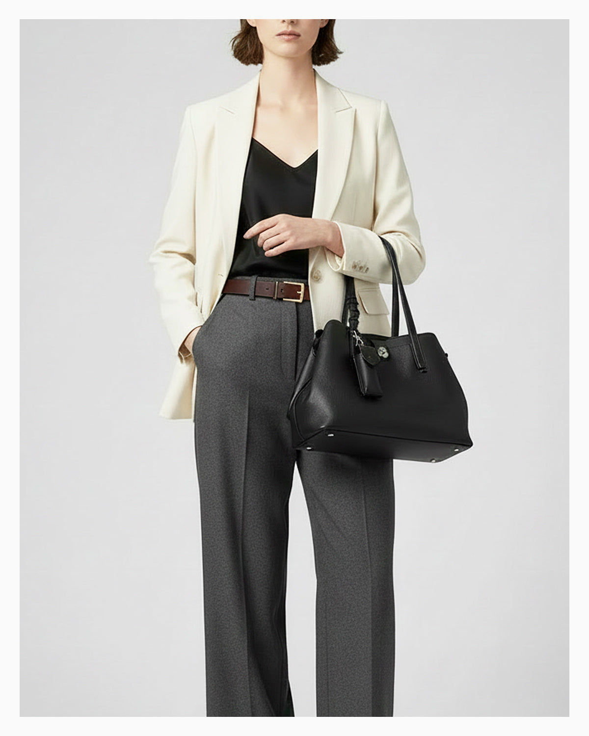 Woman in a smart-casual outfit with an Elegant Genuine Leather Black Tote Bucket Bag with Spacious Interior, Stylish Knot Detail and detachable leather lipstick pouch