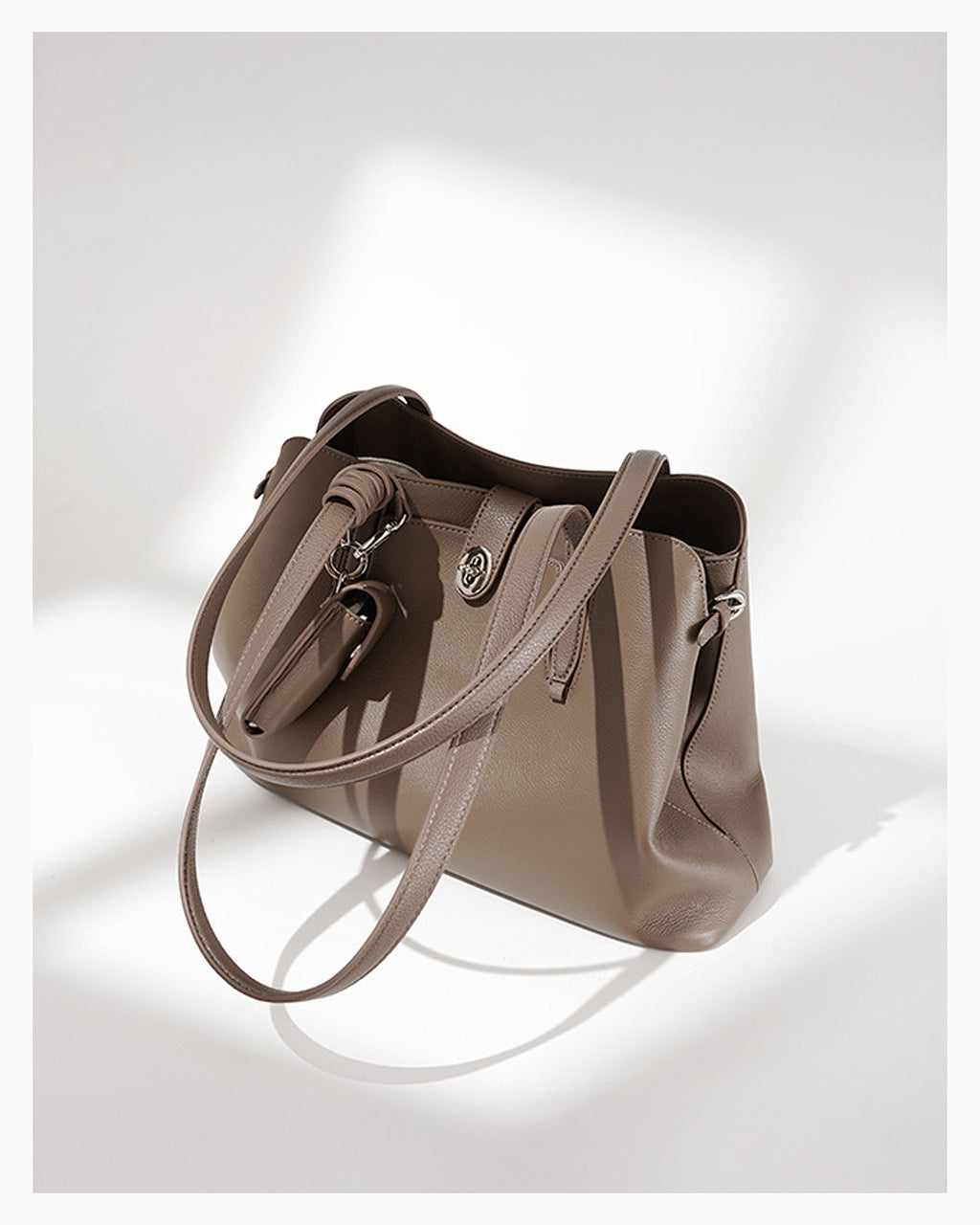 Side view of the Women's Elegant Genuine Leather Beige Gray Tote Bucket Bag with Spacious Interior and Detachable Leather Lipstick Pouch