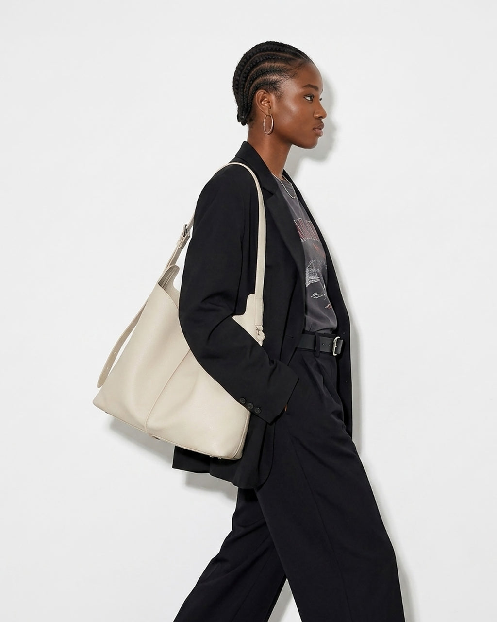 A stylish woman in a black fashion-forward outfit carries an Off-White Genuine Leather Tote Bag with an Adjustable Strap