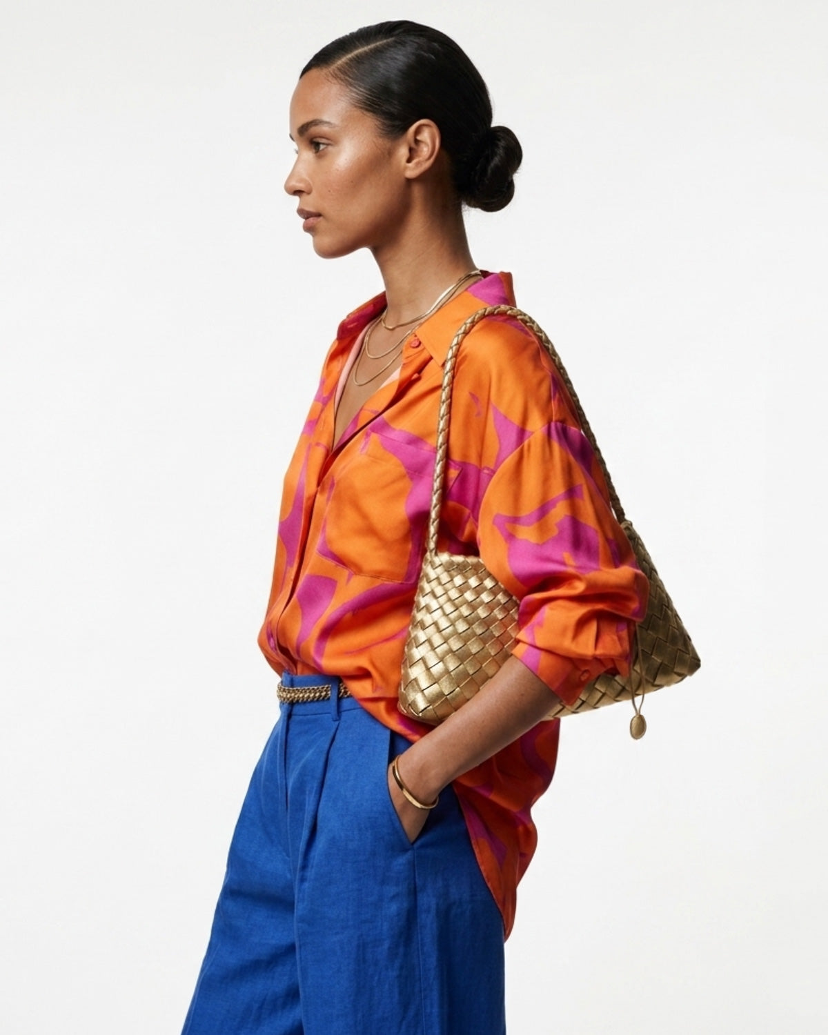 Woman in a vibrant and stylish summer outfit carries a Vegan Leather Woven Shoulder Bag in Champagne Gold Color with Removable Pouch