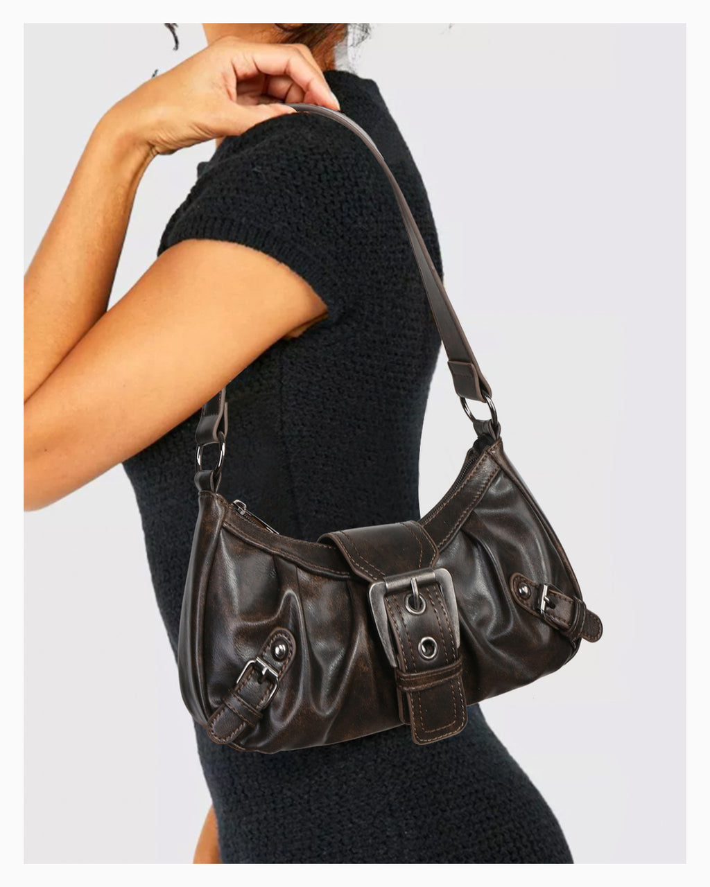 A woman in a chic knitted black dress with a trendy Y2K vegan leather shoulder coffee-color bag with buckle detail