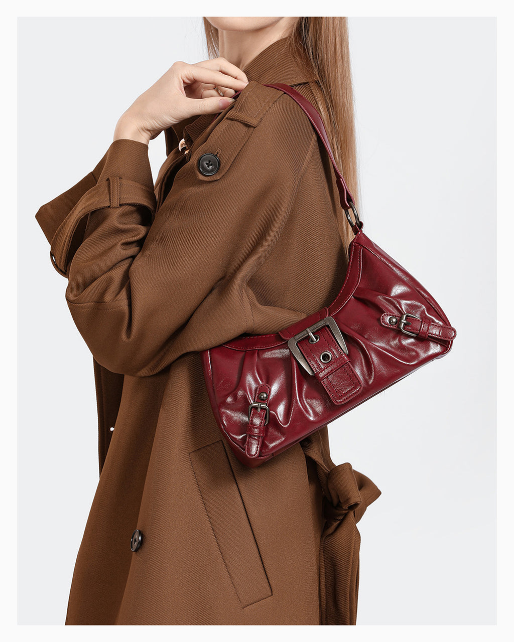 A woman in a brown coat with a trendy vegan leather shoulder dark red bag with buckle details