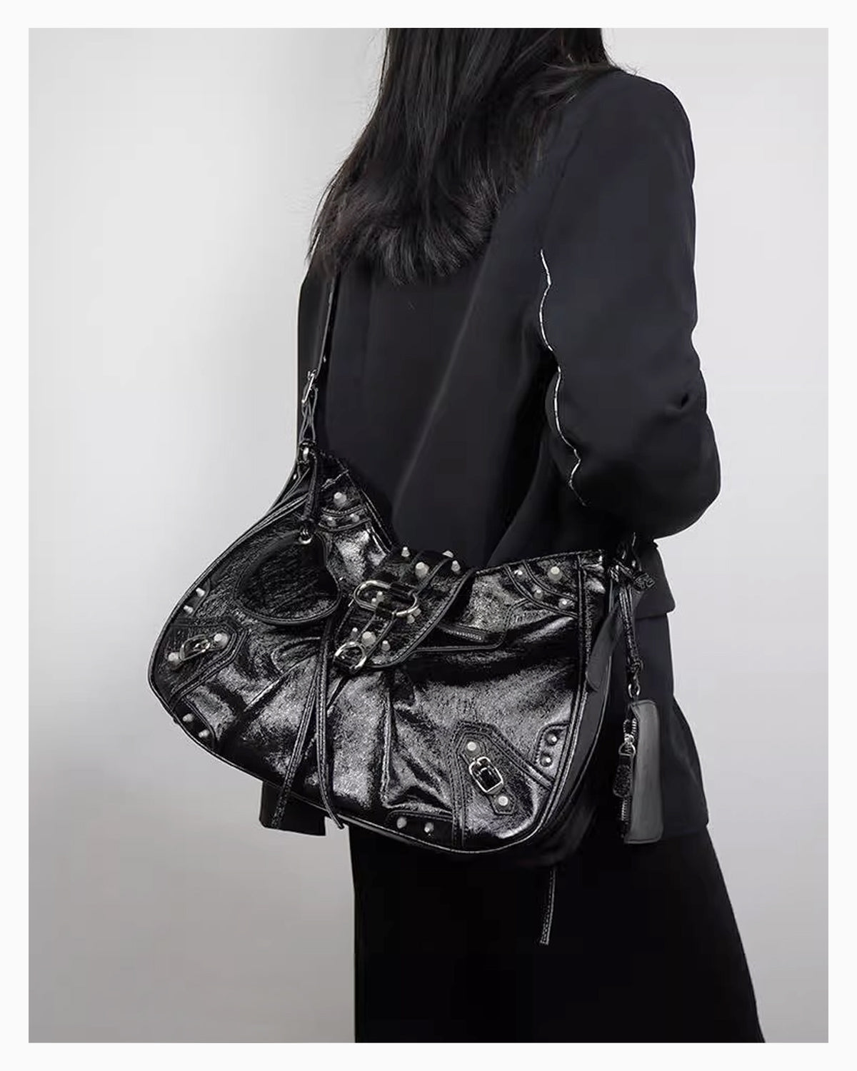 A woman in a black coat wearing a Black Studded Y2K Statement Vegan Leather Handbag with adjustable single strap