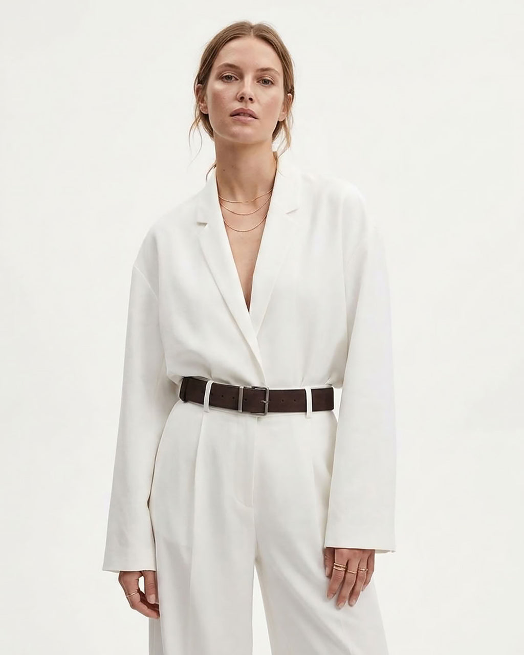 A woman modeling a white long-sleeve blazer-style top with matching white trousers and a coffee-colored genuine Suede leather Belt with a silver rectangular buckle