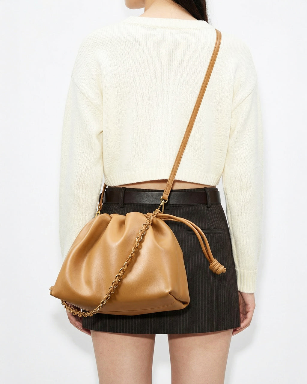 Woman in a stylish casual outfit with a trendy Genuine Leather Drawstring Shoulder Bag with Gold Chain Accent in Yellow Brown Color