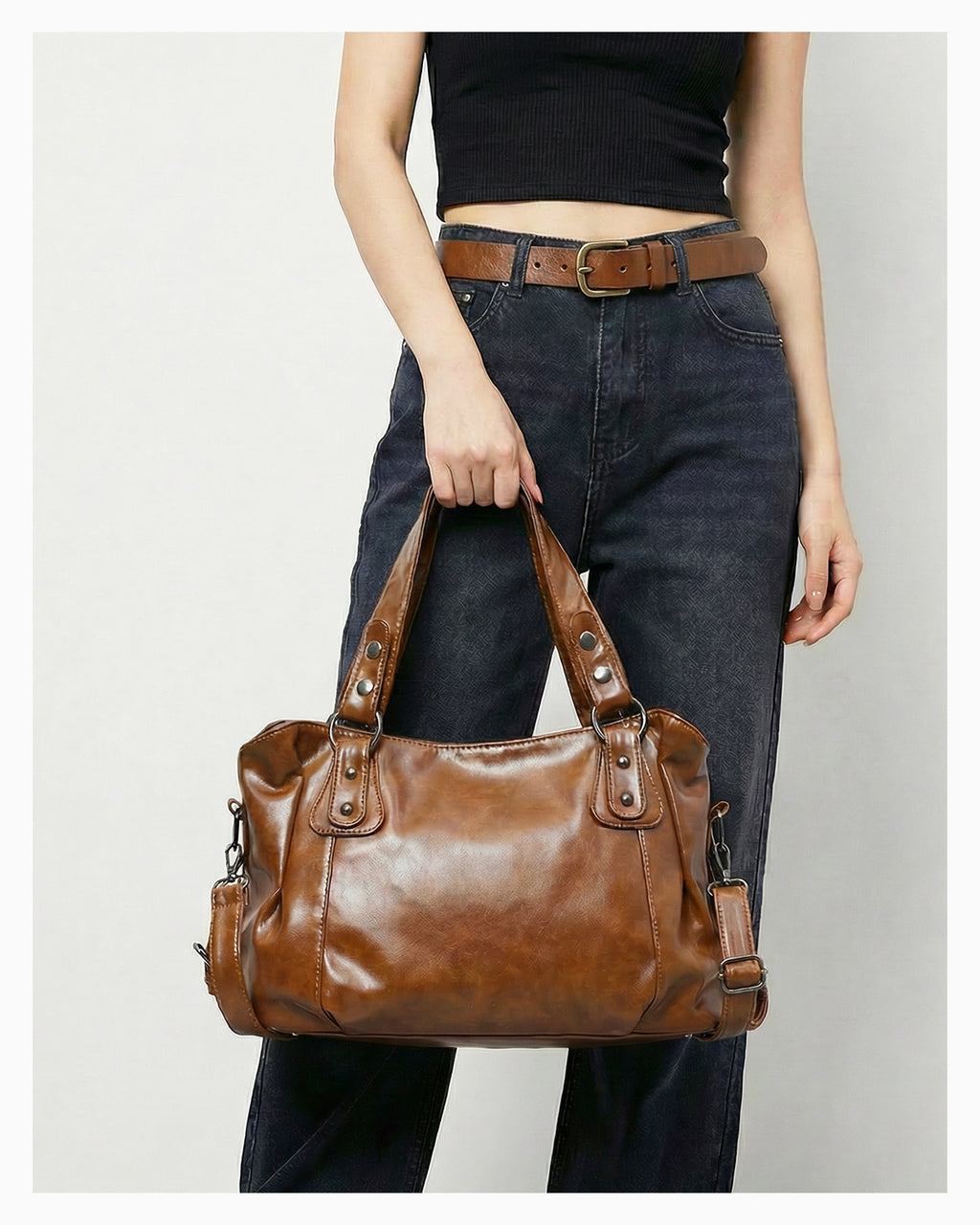 Woman in a casual outfit holds a Chic Vegan Leather Shoulder Brown Bag with Spacious Interior and Adjustable Strap