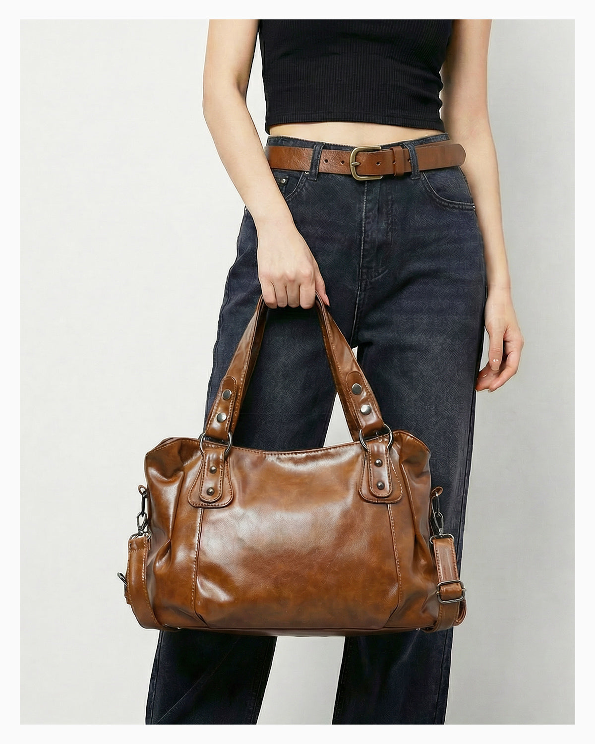 Woman in a casual outfit holds a Chic Vegan Leather Shoulder Brown Bag with Spacious Interior and Adjustable Strap