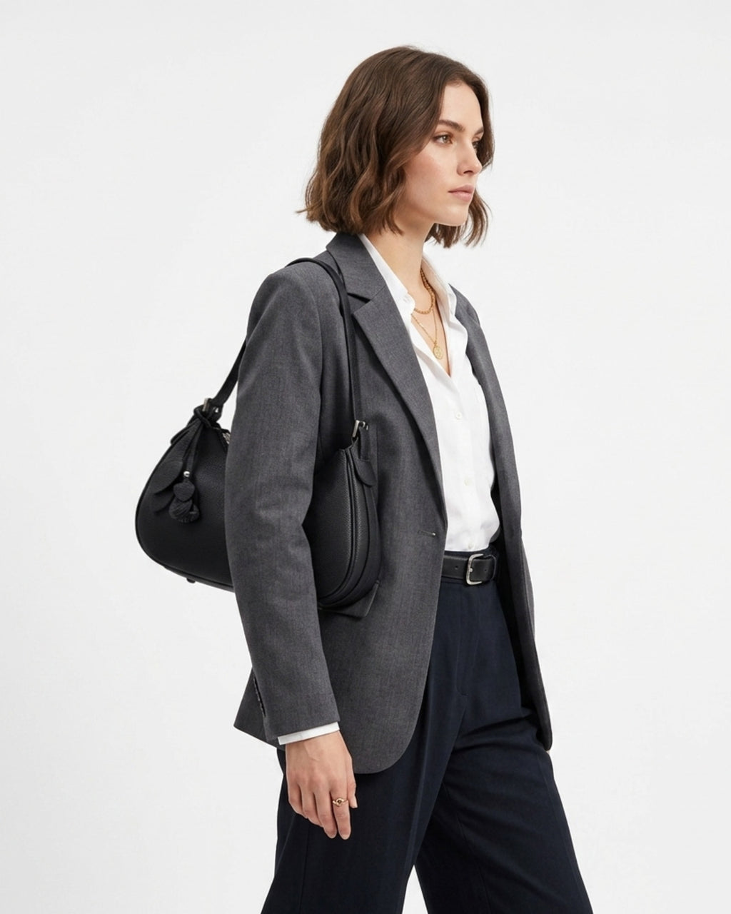 A woman in a stylish smart-casual outfit with a Genuine Leather Crescent Baguette Shoulder Bag in a black color