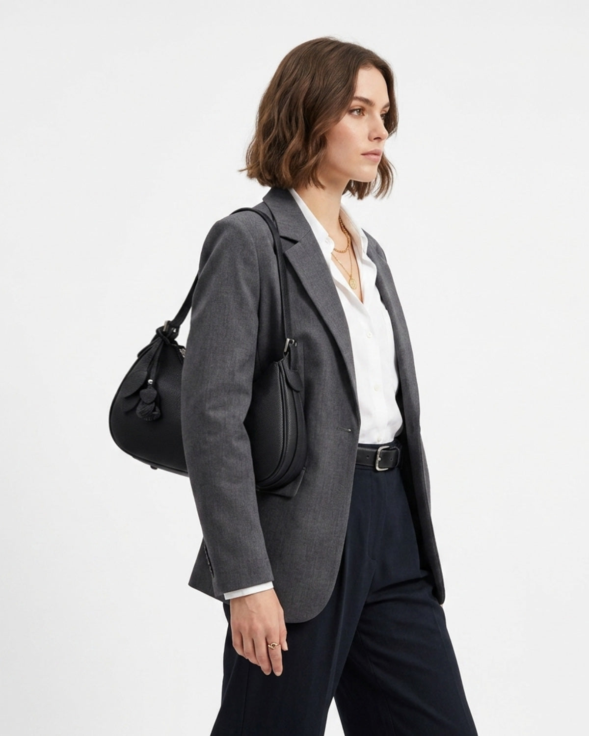 A woman in a stylish smart-casual outfit with a Genuine Leather Crescent Baguette Shoulder Bag in a black color