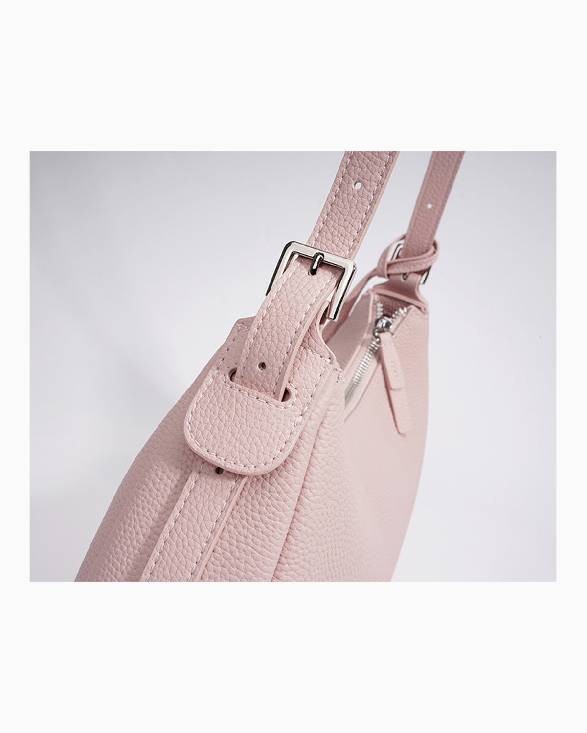 Strap and stitching details of the Genuine Leather Crescent Baguette Shoulder Bag in a Peach Pink Color