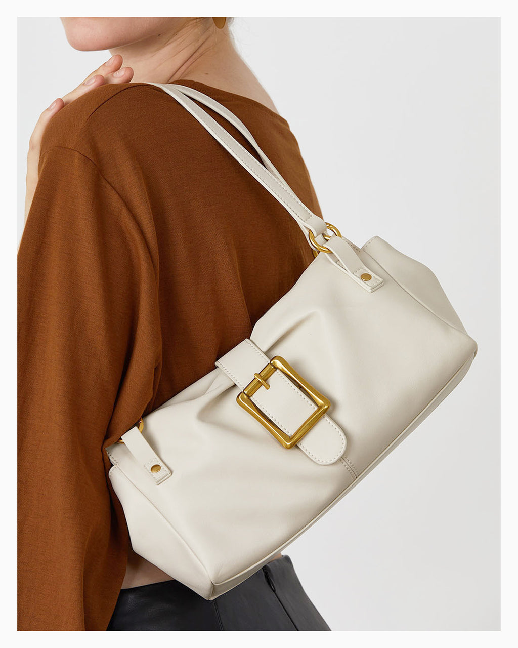 A woman wearing an Elegant Genuine Leather Shoulder White Bag with a Gold Buckle