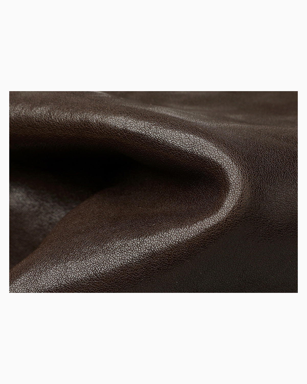A close-up of dark brown textured leather fabric with soft folds and a smooth, slightly glossy surface.