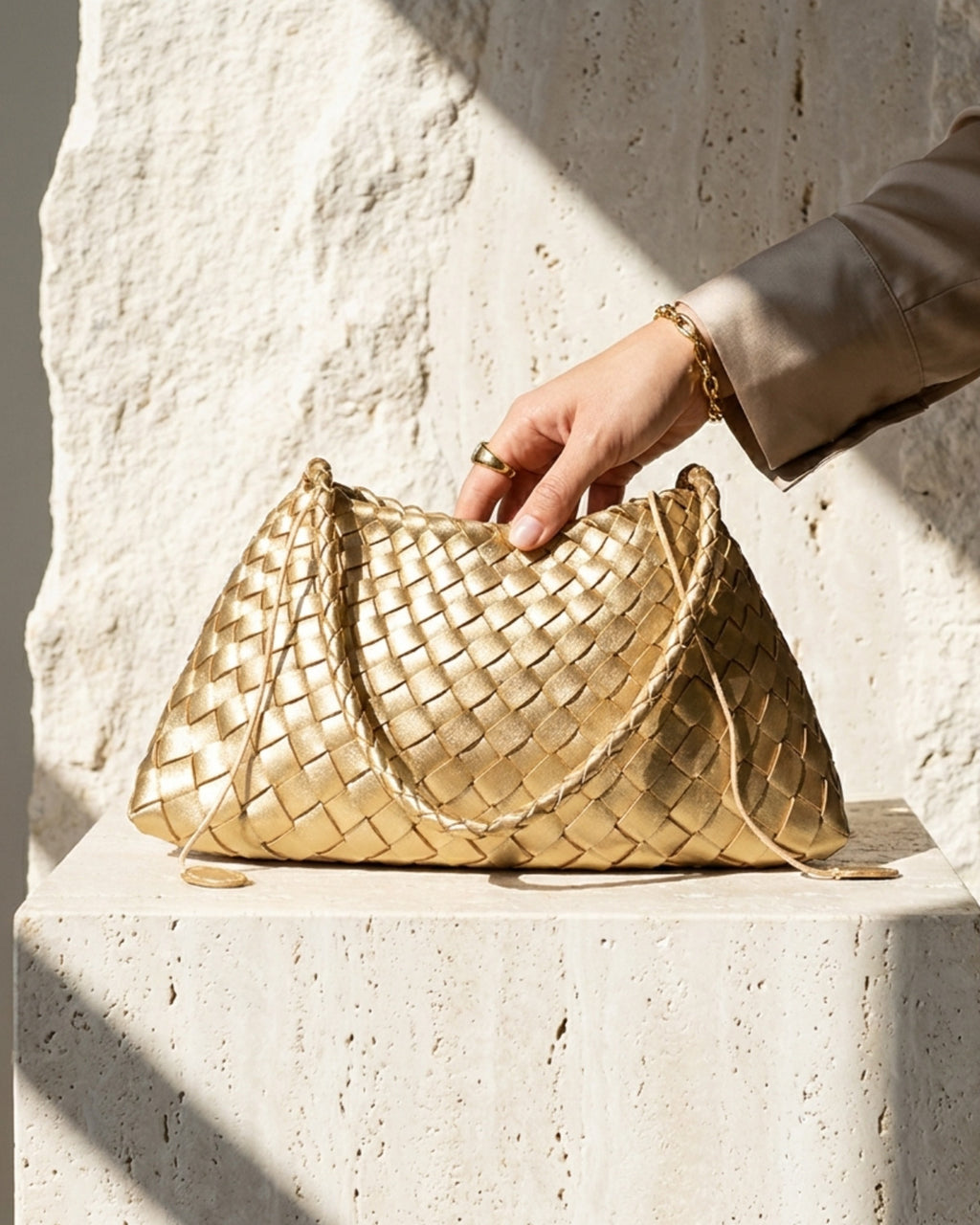 Woman's Hand touching a Vegan Leather Woven Shoulder Bag in Champagne Gold Color