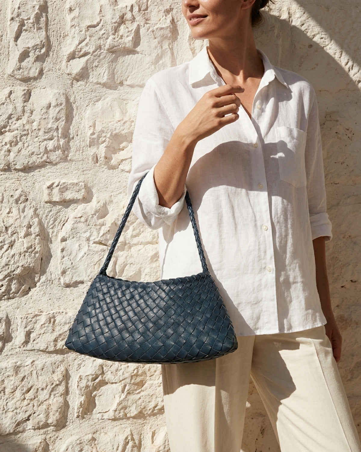 A woman in a casual summer outfit carries a trendy Vegan Faux Leather Woven Shoulder Bag in Victoria Blue Color