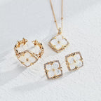 A video of a jewelry set of 18K White Gold Plated S925 Silver floral stud earrings with white mother-of-pearl flower centers and cubic zirconia halos, matching necklace and open ring
