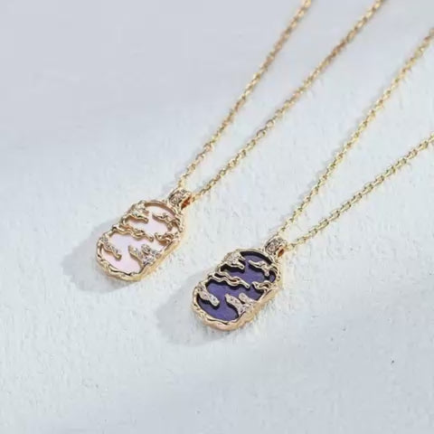 Vintage landscape pendant necklaces in lapis lazuli and mother-of-pearl, showing gold-tone mountain and cloud details with cubic zirconia accents.